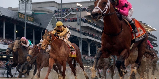 Luis Saez, in pink silk, crosses the finish line with maximum safety against Flavien Prat, in yellow silk, at Country House, in Saturday's Kentucky Derby. (AP Photo / Matt Slocum)