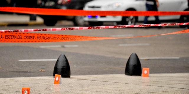 Evidence tent markers dot the crime scene where lawmaker Hector Olivares was seriously injured and another man was killed after they were shot at from a parked car near Congress in Buenos Aires, Argentina, Thursday, May 9, 2019. (AP Photo/Natacha Pisarenko)