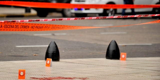 Evidence tent markers dot the crime scene where lawmaker Hector Olivares was seriously injured and another man was killed after they were shot at from a parked car near Congress in Buenos Aires, Argentina, Thursday, May 9, 2019.