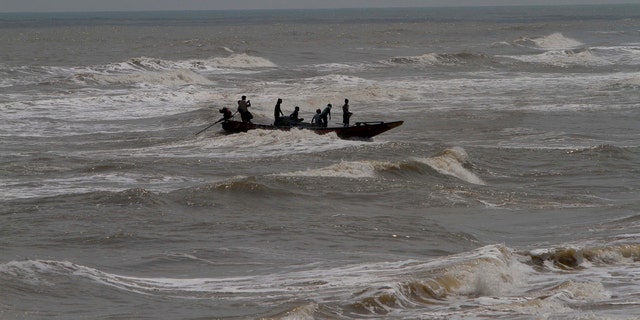 In this Wednesday, May 1, 2019 photo, Indian fishermen attempt to bring their boat ashore amid strong winds at Chandrabhaga beach in Puri district of eastern Odisha state, India.