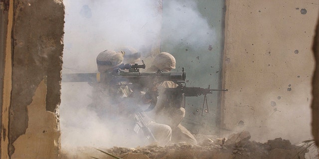 U.S. Marines of the Light Armored Reconnaissance (LAR) company of 1st Battalion 3rd Marines fire a rocket to clear houses at the site where four insurgents staged a bloody counter-attack, killing one American and wounding many others November 23, 2004, in Fallujah, Iraq.