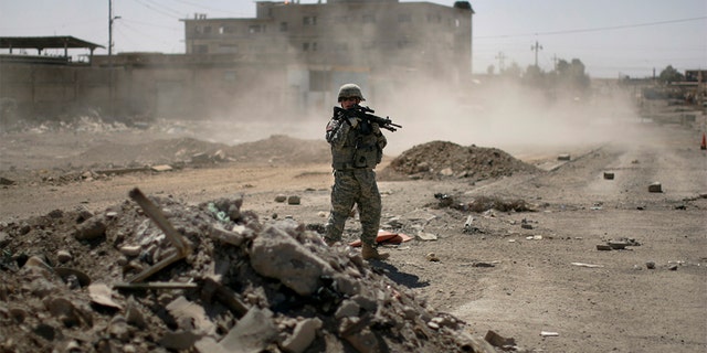 FILE -- June 19, 2008: A U.S. soldier secures the road while Major-General Mark Hertling, the commander of the U.S. forces in northern Iraq, holds a joint battlefield circulation patrol with U.S. and Iraqi soldiers on the streets in Mosul. REUTERS/Eduardo Munoz 