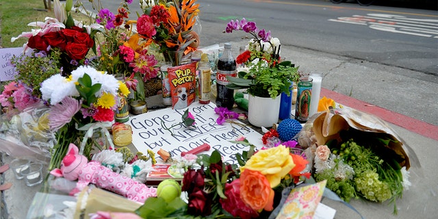 In this Wednesday, May 8, 2019, photo flowers and cards rest on a memorial for Jessica Bingaman, a popular dog walker, who was killed along with five of six dogs she was transporting in Long Beach, Calif. (Brittany Murray/The Orange County Register via AP)