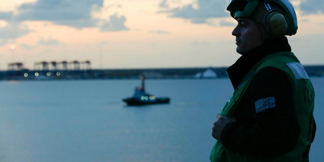 In this Thursday, May 9, 2019 photo released by the U.S. Navy, Aviation Maintenance Administrationman 2nd Class Jason Caldwell, assigned to the "Jolly Rogers" of Strike Fighter Squadron 103, observes sunrise on the flight deck of the Nimitz-class aircraft carrier USS Abraham Lincoln while transiting the Suez Canal in Egypt. (Mass Communication Specialist 3rd Class Amber Smalley, U.S. Navy via AP)