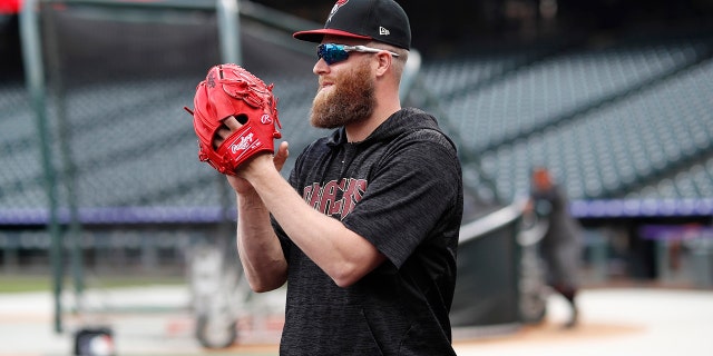Arizona Diamondbacks relief pitcher Archie Bradley applauds for teammates as they warm up before facing the Colorado Rockies in a baseball game Saturday, May 4, 2019, in Denver. (AP Photo/David Zalubowski)