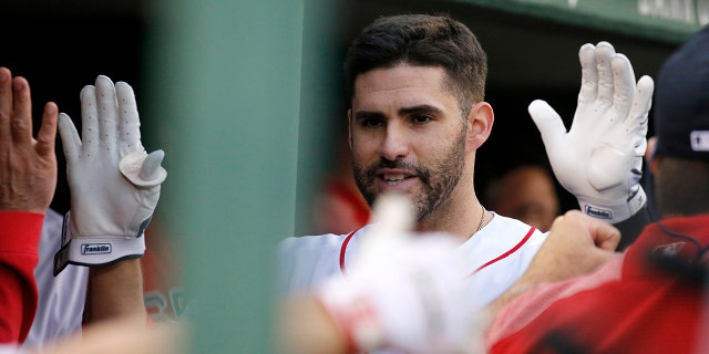 Boston Red Sox's J.D. Martinez is congratulated in the dugout after hitting a home run during the eighth inning of a baseball game against the Cleveland Indians, Monday, May 27, 2019, in Boston. (AP Photo/Mary Schwalm)