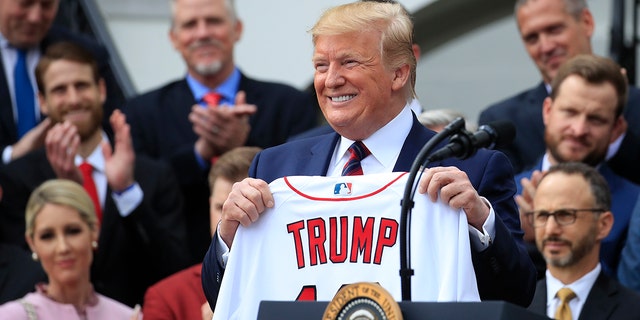President Donald Trump shows off a Red Sox jersey presented to him during a ceremony welcoming the Boston Red Sox the 2018 World Series baseball champions to the White House, Thursday, May 9, 2019, in Washington. (Associated Press)