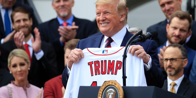 President Donald Trump shows off a Red Sox jersey presented to him during a ceremony welcoming the Boston Red Sox the 2018 World Series baseball champions to the White House, Thursday, May 9, 2019, in Washington. (Associated Press)