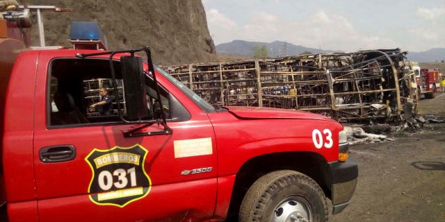 Firefighters work at the site of a deadly road accident between a bus and a semi-trailer, on a mountain road in Veracruz state, Mexico, on Wednesday. (Civil Protection Office of Veracruz via AP)