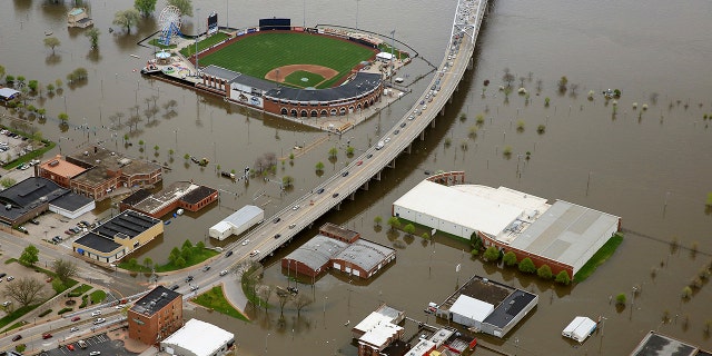 An aerial photo of Davenport, Iowa, shows Modern Woodmen Park, top, and the surrounding area covered by Mississippi River floodwaters, Friday, May 3, 2019. Iowa Gov. Kim Reynolds visited Davenport Friday. Several blocks of downtown Davenport were flooded this week when a flood barrier succumbed to the onslaught of water. (Kevin E. Schmidt/Quad City Times via AP)
