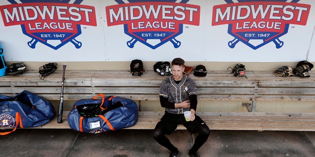Quad Cities River Bandits infielder Trey Dawson sits in the dugout before a Class-A Midwest League baseball game against the Cedar Rapids Kernels in Cedar Rapids, Iowa. (AP Photo/Charlie Neibergall)