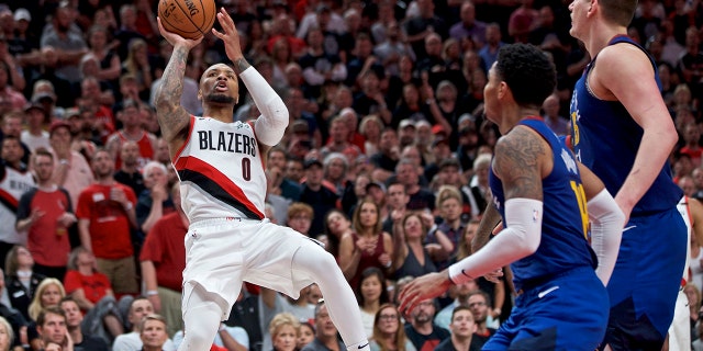 Portland Trail Blazers guard Damian Lillard, left, shoots over Denver Nuggets guard Gary Harris, center, and center Nikola Jokic, right, during the second half of Game 6 of an NBA basketball second-round playoff series Thursday, May 9, 2019, in Portland, Ore. The Trail Blazers won 119-108. (AP Photo/Craig Mitchelldyer)