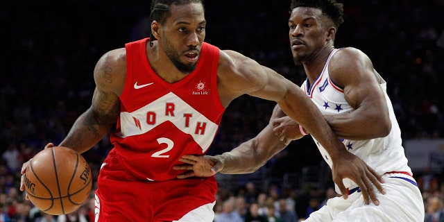 Toronto Raptors' Kawhi Leonard, left, drives against Philadelphia 76ers' Jimmy Butler, right, during the second half of Game 4 of a second-round NBA basketball playoff series, Sunday, May 5, 2019, in Philadelphia. The Raptors won 101-96. (AP Photo/Chris Szagola)