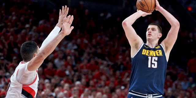Denver Nuggets center Nikola Jokic, right, looks to shoot over Portland Trail Blazers center Enes Kanter during the first half of Game 4 of an NBA basketball second-round playoff series Sunday, May 5, 2019, in Portland, Ore. (AP Photo/Craig Mitchelldyer)