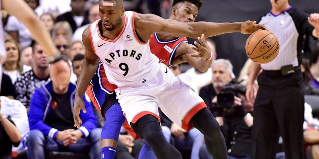 Philadelphia 76ers guard Jimmy Butler (23) fails to steal the ball as Toronto Raptors center Serge Ibaka (9) moves the ball down the court during first half NBA Eastern Conference semifinal action in Toronto on Sunday, May 12, 2019. (Frank Gunn/The Canadian Press via AP)
