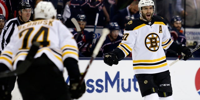 Boston Bruins forward Patrice Bergeron, right, celebrates his goal against the Columbus Blue Jackets with forward Jake DeBrusk during the first period of Game 4 of an NHL hockey second-round playoff series in Columbus, Ohio, Thursday, May 2, 2019. (AP Photo/Paul Vernon)