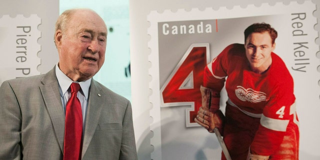 FILE - In this Feb. 1, 2019, file photo, former Detroit Red Wings player Red Kelly stands beside his Canadian stamp during the unveiling of the NHL stamp series featuring defensemen from the original six NHL teams, at the Hockey Hall of Fame in Toronto. (Hannah Yoon/The Canadian Press via AP, File)