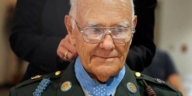 Robert Maxwell's Medal of Honor is fastened by Mary Spilde, president of Lane Community College, at a ceremony dedicating the Maxwell Student Veteran Center in his in Eugene, Ore. (AP Photo/The Register-Guard, Paul Carter)
