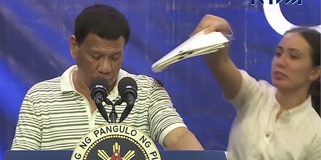 A female aide quickly intervened to save President Duterte from the awkward moment, but her efforts to remove the cockroach failed, prompting the insect to run down the front of the president’s shirt.