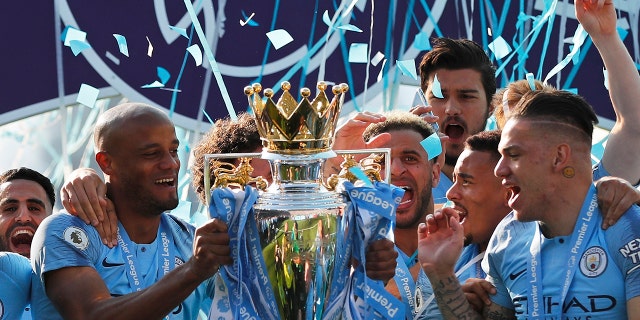 Manchester City's Vincent Kompany lifts the English Premier League trophy after the English Premier League soccer match between Brighton and Manchester City at the AMEX Stadium in Brighton, England, Sunday, May 12, 2019. Manchester City defeated Brighton 4-1 to win the championship. (AP Photo/Frank Augstein)