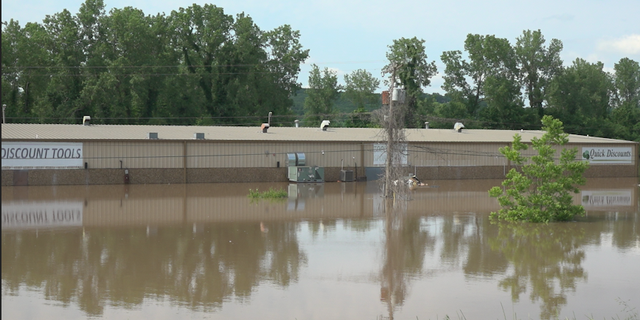 The flooding has already submerged Fort Smith business Quick Discounts near a bridge over the river connecting Fort Smith and Van Buren.