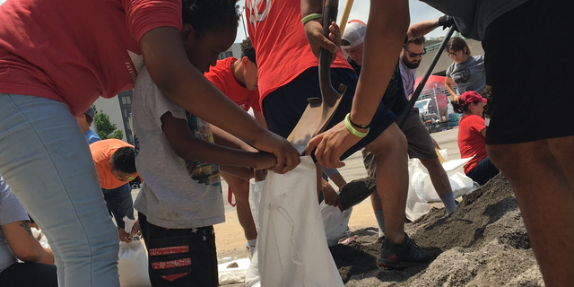 Four-year-old Jeremiah helps load sandbags in Fort Smith