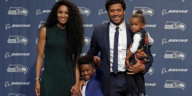 O quarterback do Seattle Seahawks NFL Russell Wilson posa para fotos com sua esposa Ciara, sua filha Sienna e o filho de Ciara, Future, quarta-feira, 17 de abril de 2019, em Renton, Washington, após uma coletiva de imprensa. No início da semana, Wilson assinou uma extensão de US $ 140 milhões e quatro anos com a equipe.