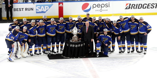 Members of the St. Louis Blues are presented the Clarence S. Campbell Bowl by NHL deputy commissioner Bill Daly after defeating the San Jose Sharks in Game 6 of the NHL hockey Stanley Cup Western Conference final series on Tuesday. (Associated Press)