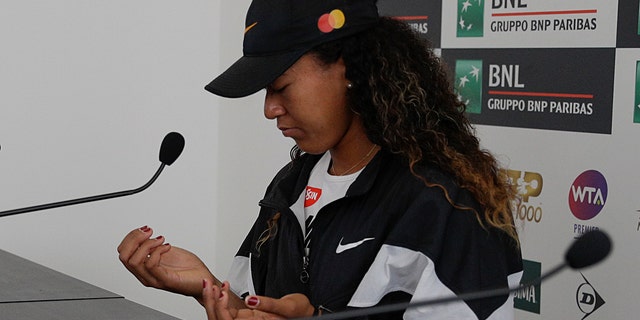 Japan's Naomi Osaka shows her hands as she meets the journalists at the Italian Open tennis tournament, in Rome, Friday, May, 17, 2019. Top-ranked Naomi Osaka withdrew from her Italian Open quarterfinal due to a right hand injury on Friday. It wasn't immediately clear how serious the injury was, or if it will affect Osaka's status for the French Open, which starts in nine days. (AP Photo/Gregorio Borgia)