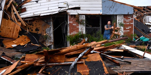 Wesley Mantooth lifts a wooden chair out a window of the home of his father, Robert, in Abilene, Texas, on Saturday, May 18, 2019.