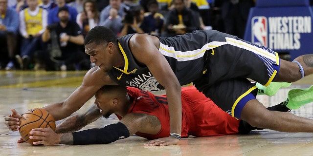 Golden State Warriors center Kevon Looney, top, reaches for the ball over Portland Trail Blazers guard Damian Lillard during the second half of Game 2 of the NBA basketball playoffs Western Conference finals in Oakland, Calif., on Thursday. (Associated Press)