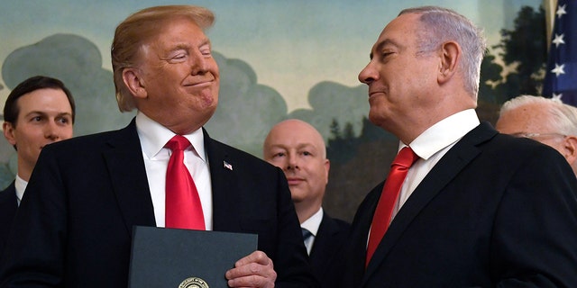 FILE - In this March 25, 2019 file photo, President Donald Trump smiles at Israeli Prime Minister Benjamin Netanyahu, right, after signing a proclamation at the White House in Washington. 