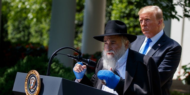 President Donald Trump looks at Rabbi Yisroel Goldstein, survivor of the California Poway synagogue shootings, speaking at a national day of prayer in the White House Rose Garden on Thursday, May 2, 2019 in Washington. . (AP Photo / Evan Vucci)