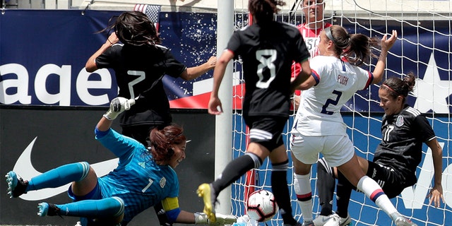 United States forward Mallory Pugh (2) scoring a goal as Mexico's Cecilia Santiago (1), Daniela Espinosa (7), Joana Robles (8) and Yamile Franco (17) tried to stop her. (AP Photo/Julio Cortez)