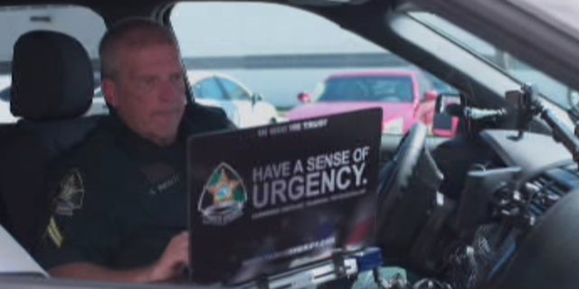 Pasco County Sheriff's Corporal Alan Wilkett uses his laptop from his service vehicle.