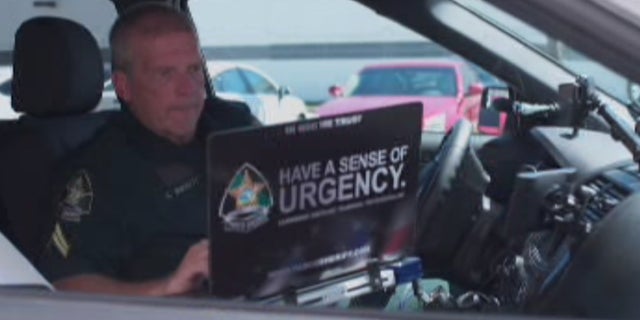 Pasco County Sheriff's Corporal Alan Wilkett uses his laptop from his service vehicle.