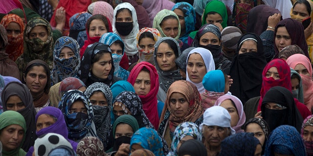 Kashmiri villagers watch the funeral procession of Zakir Musa, a top militant commander linked to al-Qaida, as it rains in Tral, south of Srinagar, Indian controlled Kashmir, Friday, May 24, 2019. (AP Photo/Dar Yasin)