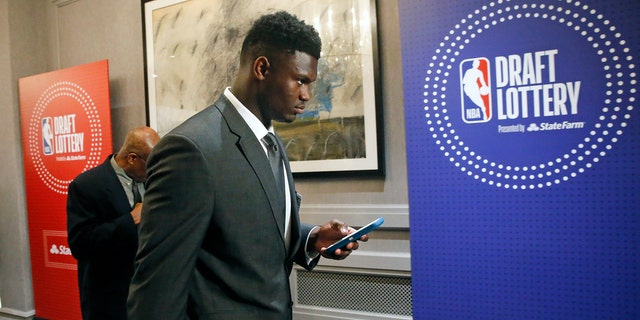 Zion Williamson checks his phone as he arrives for the NBA draft lottery in Chicago Tuesday night. (AP Photo/Nuccio DiNuzzo)