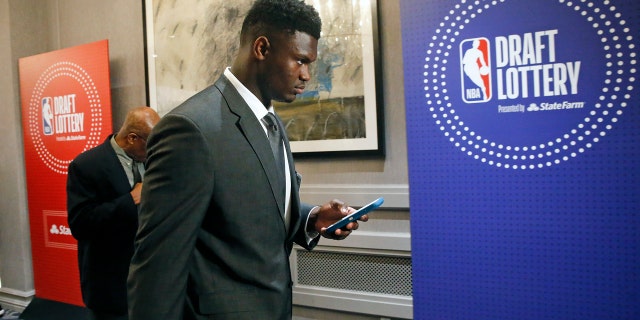 Zion Williamson checks his phone as he arrives for the NBA draft lottery in Chicago Tuesday night. (AP Photo/Nuccio DiNuzzo)