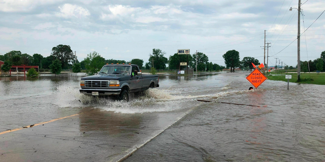 A pickup truck evacuates from an area in north Jefferson City Missouri as floodwaters from the Missouri River rise over the road on Friday, May 24, 2019. The flooding come as residents are still cleaning up from a powerful tornado that hit the state's capital city on May 22. (AP Photo/David A. Lieb)
