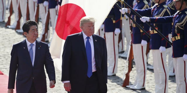 U.S. President Donald Trump, second from left, reviews an honor guard during a welcome ceremony, escorted by Japanese Prime Minister Shinzo Abe at Akasaka Palace in Tokyo, Nov. 6, 2017. (Associated Press)