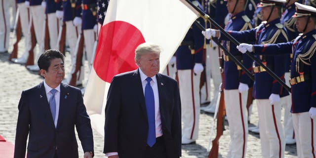 U.S. President Donald Trump, second from left, reviews an honor guard during a welcome ceremony, escorted by Japanese Prime Minister Shinzo Abe at Akasaka Palace in Tokyo, Nov. 6, 2017. (Associated Press)