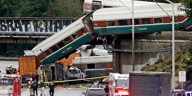 In this Dec. 18, 2017, file photo, cars from an Amtrak train lay spilled onto Interstate 5 alongside smashed vehicles as some train cars remain on the tracks above in DuPont, Wash.