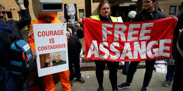 Protesters outside court as Julian Assange will appear to be sentenced on charges of jumping British bail seven years ago, in London, Wednesday May 1, 2019. Founder of WikiLeaks whistleblower website, Assange faces a separate court hearing later, on a U.S. extradition request, after being arrested at the Ecuadorian embassy April 11, when his political asylum was withdrawn.(AP Photo/Matt Dunham)