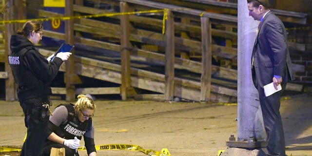 Police work near the scene where authorities say several people were shot, at least one fatally, Sunday, April 28, 2019, in Baltimore.