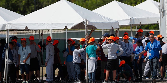 Migrant children stand outside the Homestead Temporary Shelter for Unaccompanied Children in Homestead, Fla, in May.