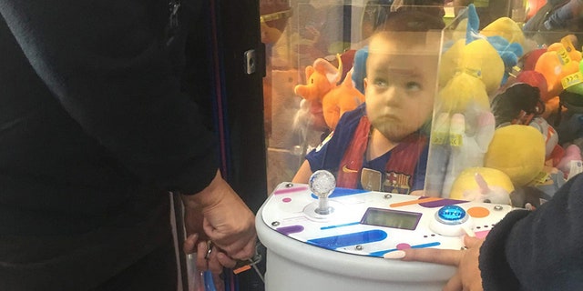 A mother-of-three was left in hysterics after finding her son Noah, pictured, had climbed into a toy arcade machine in hopes of nabbing a teddy bear.