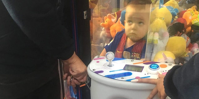 A mother-of-three was left in hysterics after finding her son Noah, pictured, had climbed into a toy arcade machine in hopes of nabbing a teddy bear.