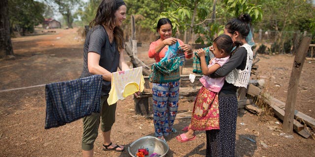 Cissie Graham Lynch works side by side with mothers in Kratie Province, Cambodia-- washing clothes and hearing about their families.