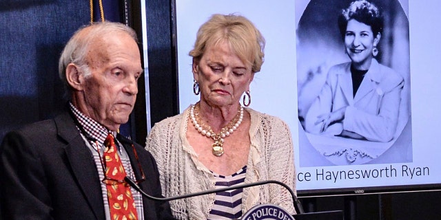 Joe Ryan, left, of Greenville stands with his wife near a photo of his late mother Alice Haynesworth Ryan, during a city police announcement of an arrest in the 1988 cold case homicide.